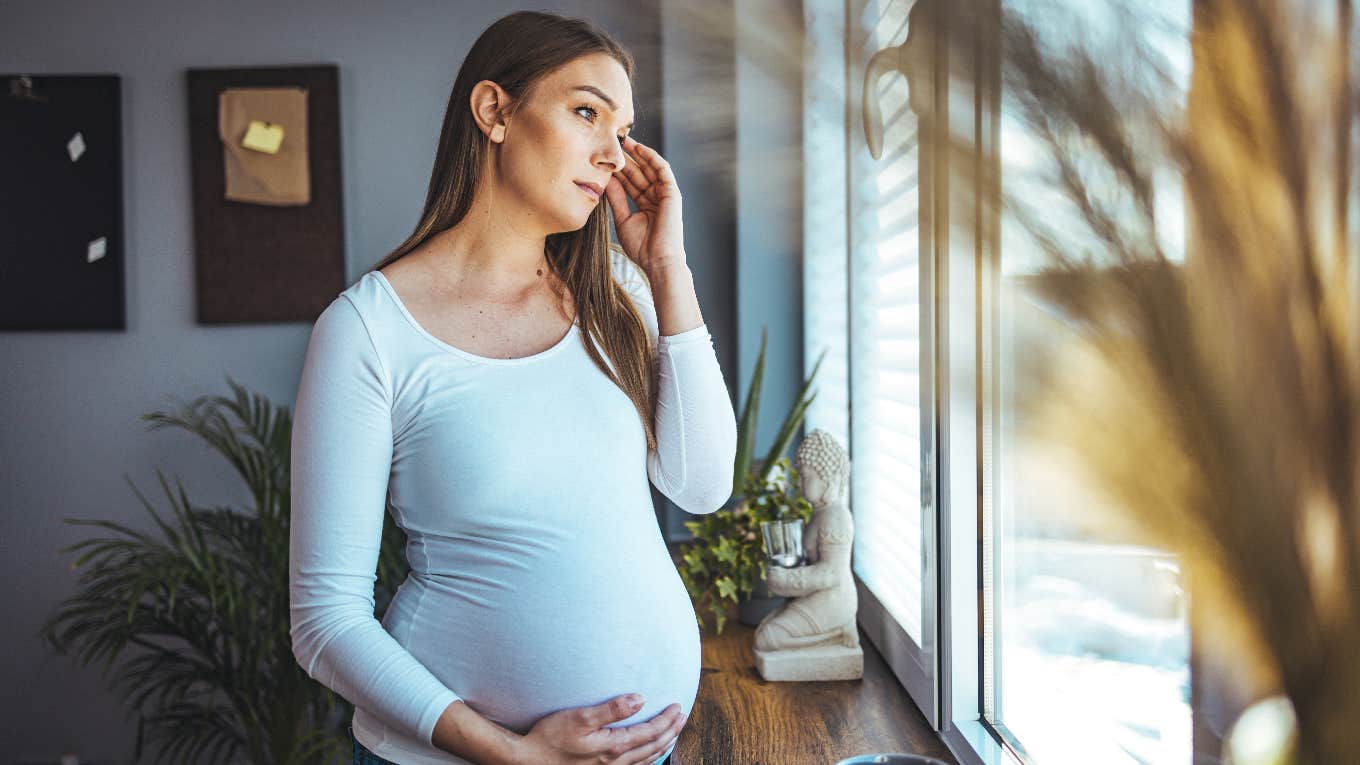 pregnant woman looking out the window