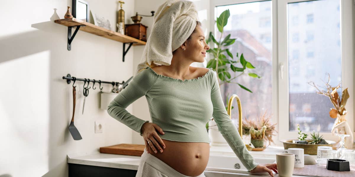 Pregnant woman looking out window