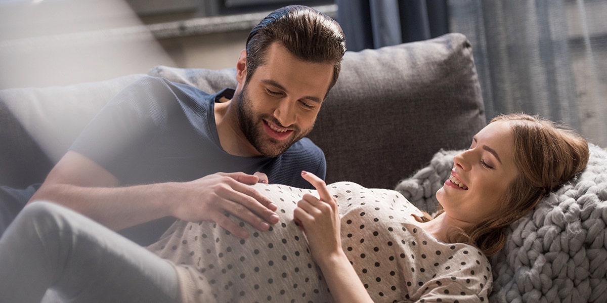 man looking at pregnant wife belly