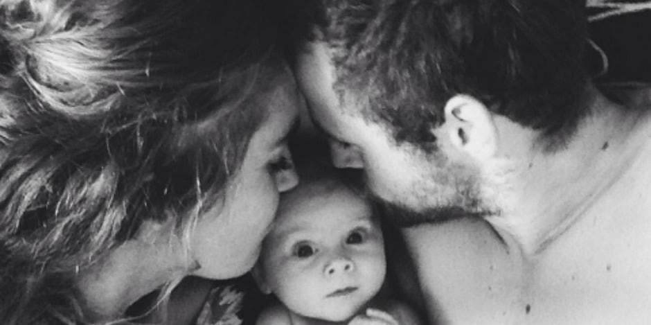 Parents kissing baby