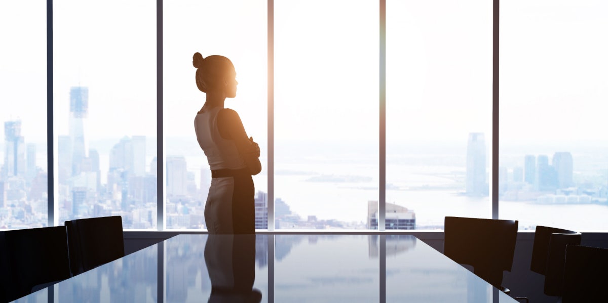 woman at work looking out city window