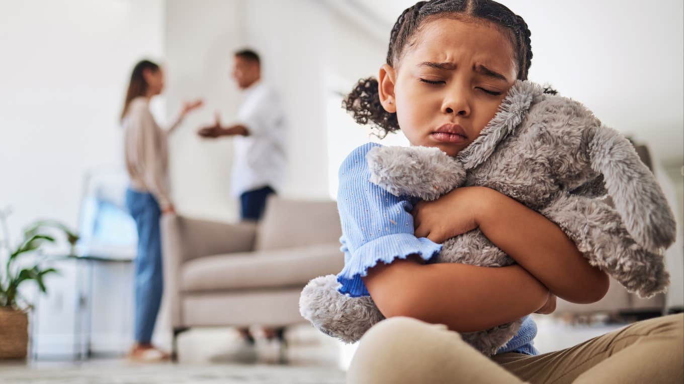 Sad girl hearing parents argue 