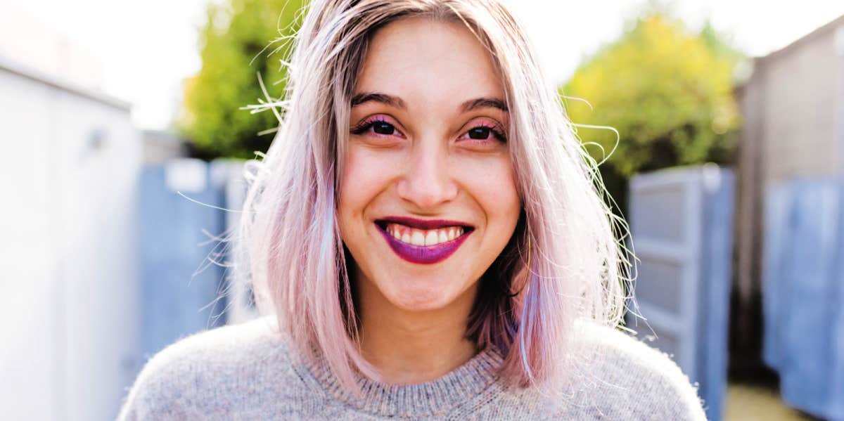 woman with trendy white hair smiles at the camera 