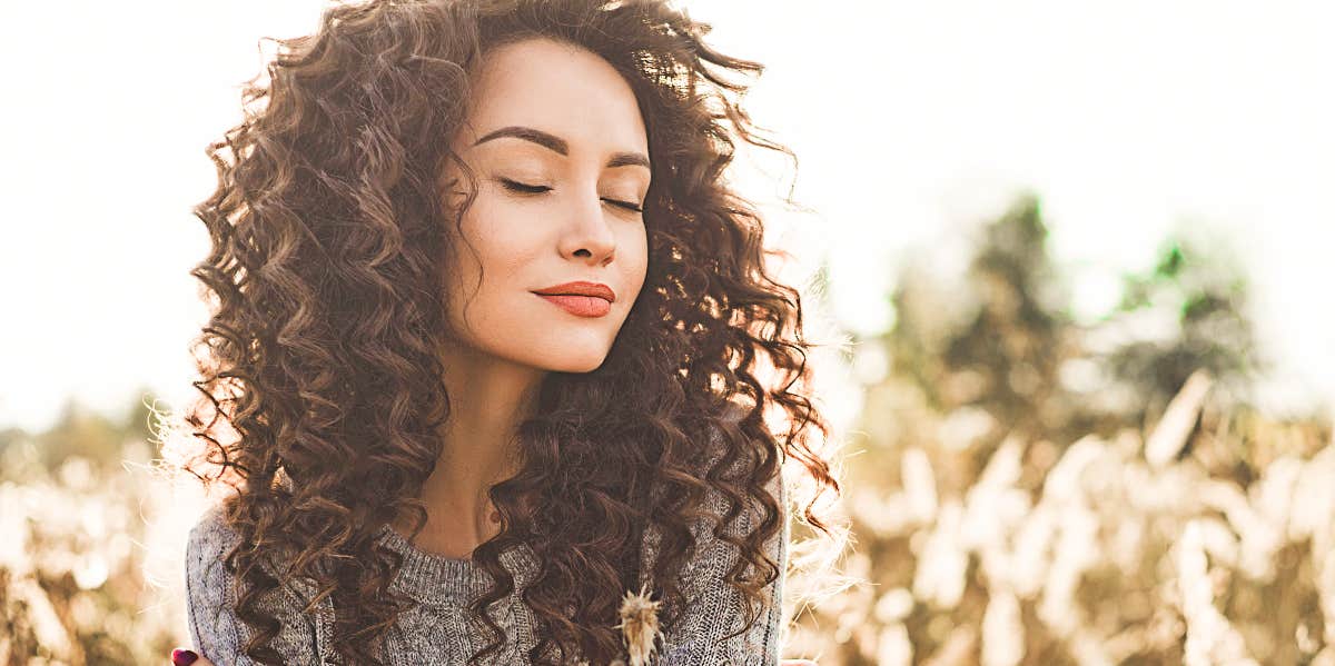 Woman in field feeling and looking calm 