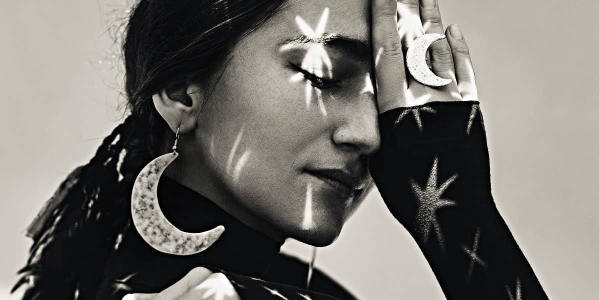 Overlooked spiritual tools, psychic skills black and white image of a woman in moon earrings with stars projected on her face