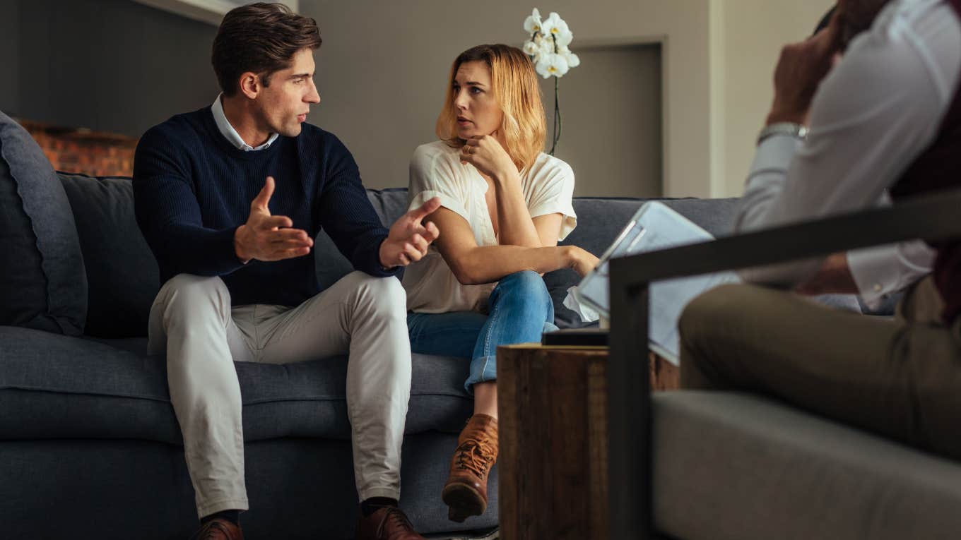 couple speaking to each other while sitting on a couch in front of a therapist