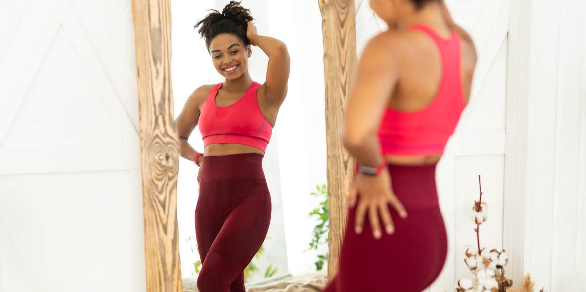 I Finally Chose To Put My Body First And Here’s How I Did It woman looking in the mirror