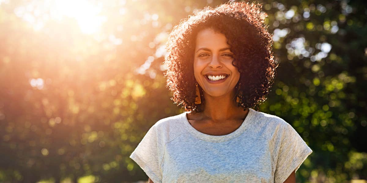 Psychological spiritual healing Confident, relaxed woman smiles outside