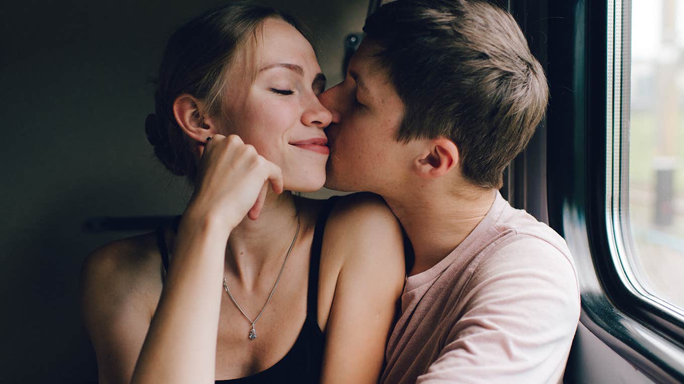 loving couple hugging, kissing near window. 