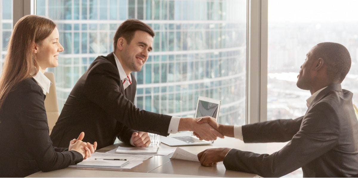 people shaking hands in business setting