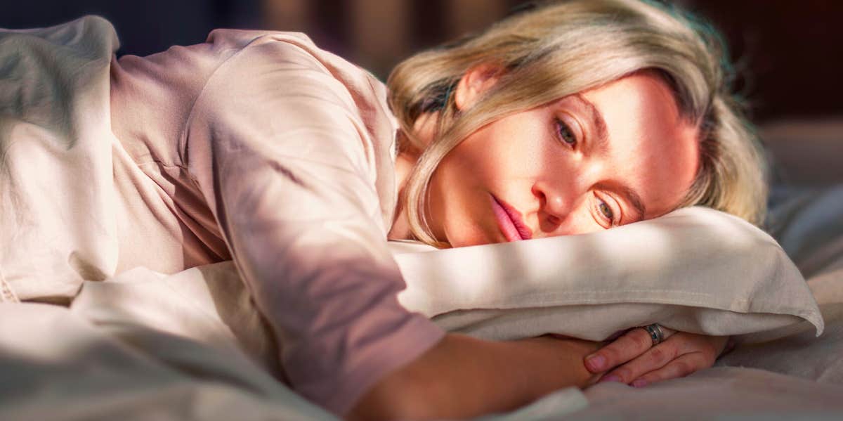 unhappy woman lying in bed