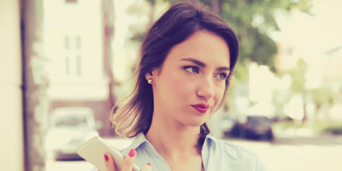 woman thinking about something holding her phone