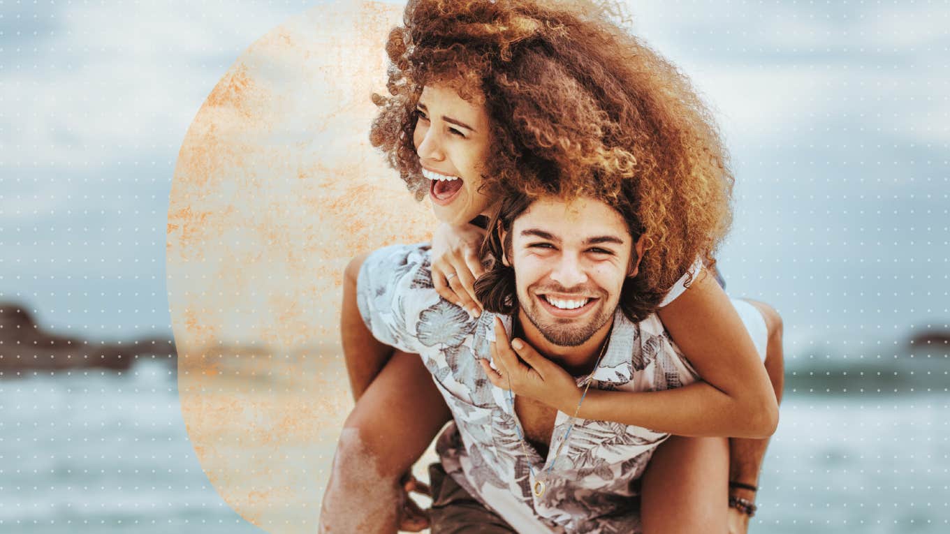 Couple spontaneously running down the beach, piggy back 