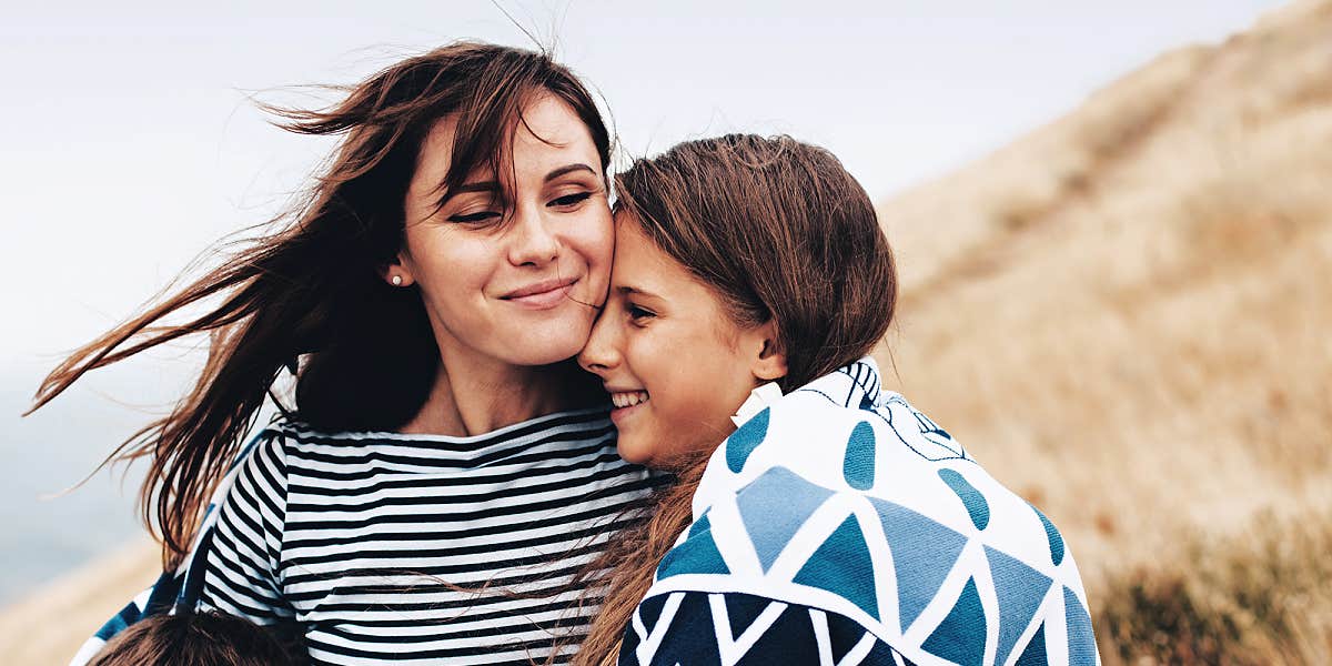 mom and daughter on a grassy dune