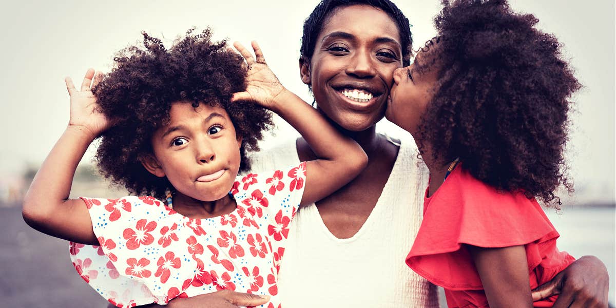 glowing happy Black mom with two young daughters