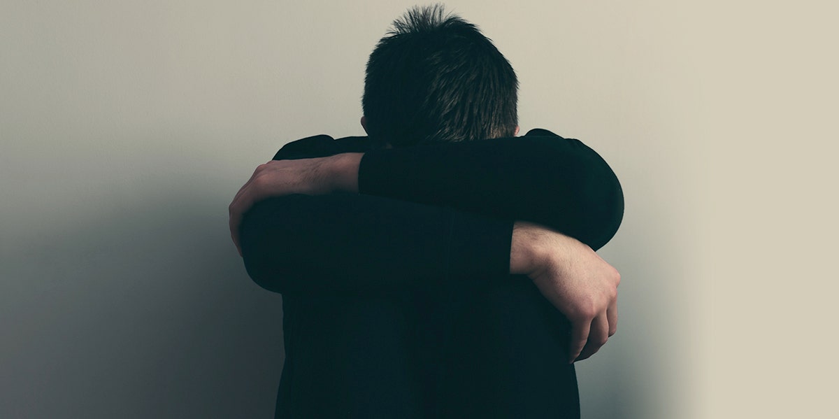 What It's Really Like To Be A Male Victim Of Rape man with head on knees