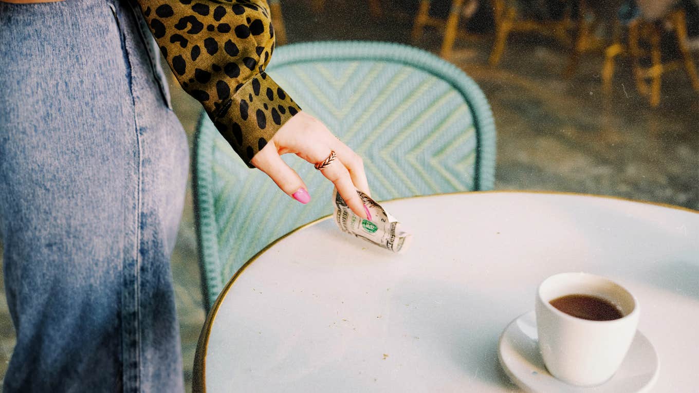 Woman taking her tip off the table she served 