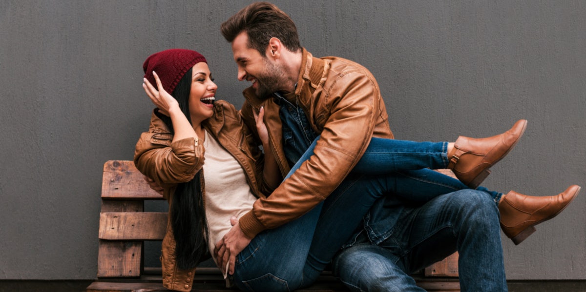 man and woman cuddling on bench