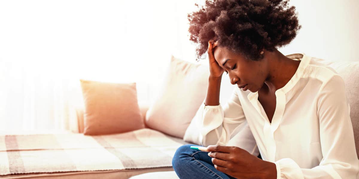 The Terrifying Reality Of Going Off Depression Meds To Have A Baby woman holding pregnancy test