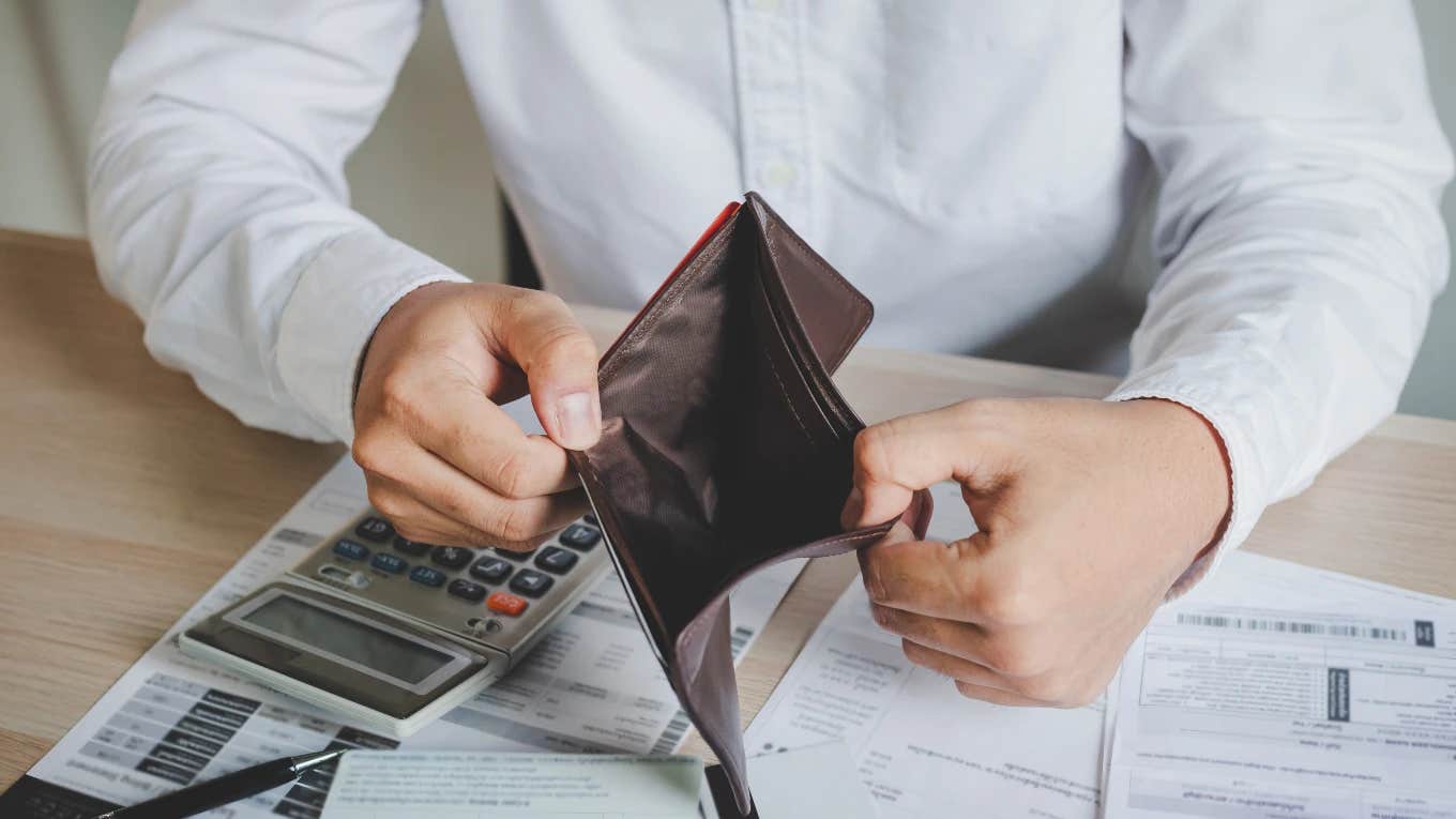 man with empty wallet frustrated about money