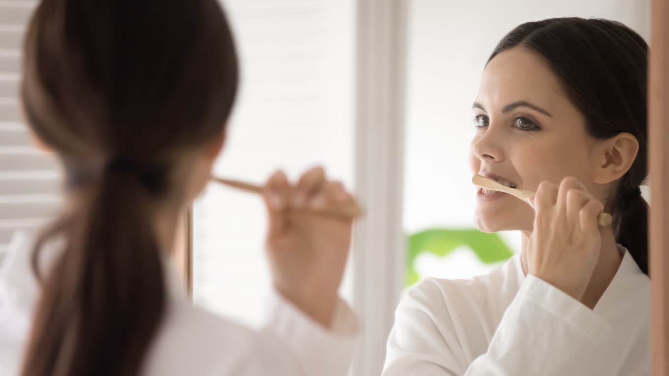 woman brushing teeth while staying at a hotel