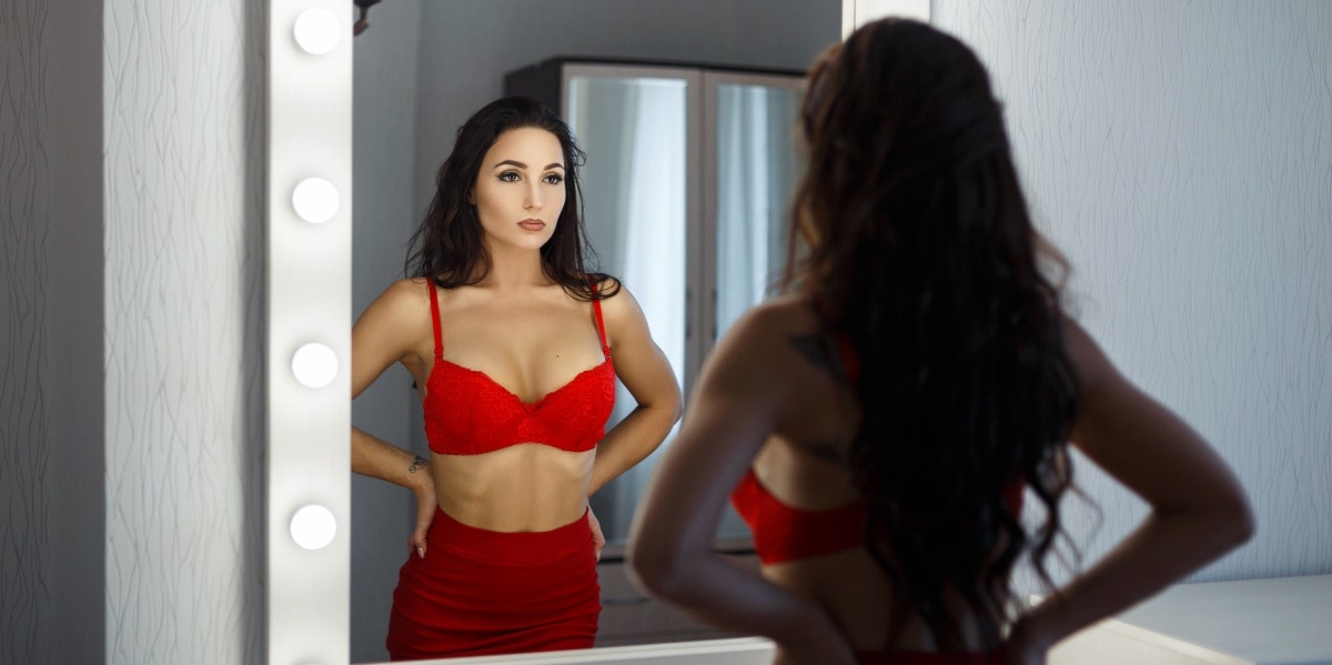 woman in lingerie looking into mirror