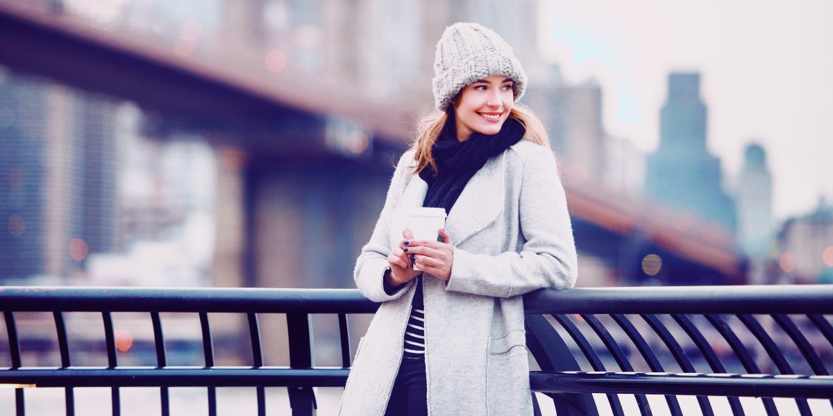 smiling woman in a white coat in city