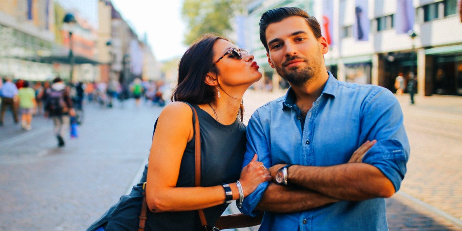 woman giving a kissy face to a man in blue button-down