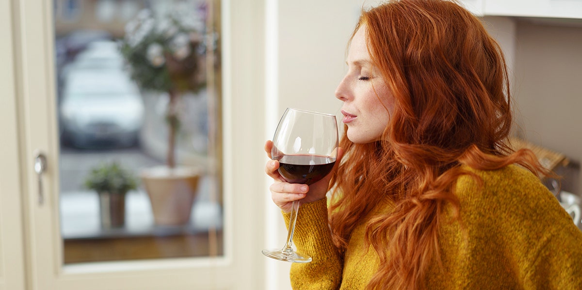 red-haired woman drinking red wine