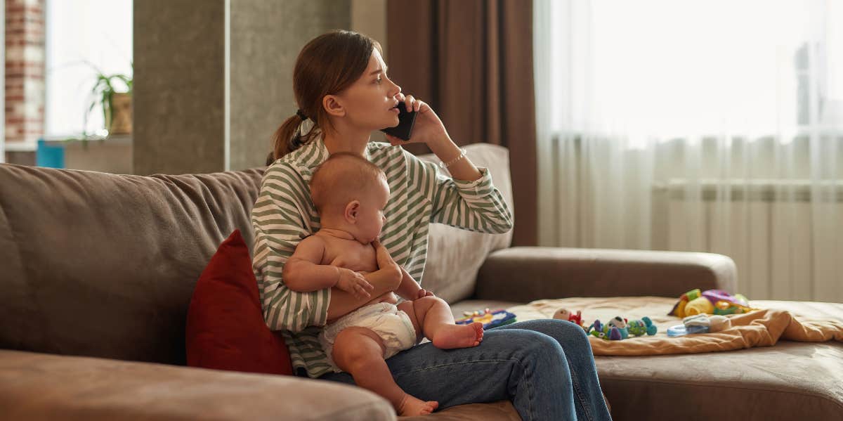 woman talking on phone while holding baby