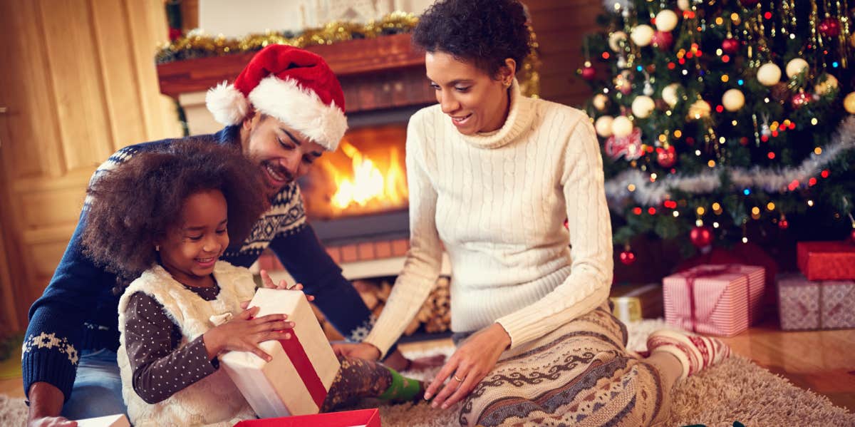 family opening Christmas gifts in front of the tree