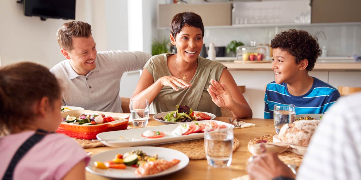 Family Eating Meal Around Table At Home Together