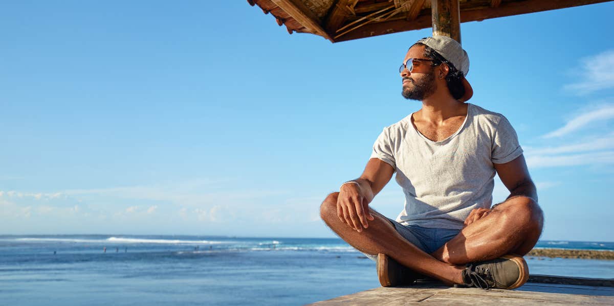 Man sitting on deck near the sea