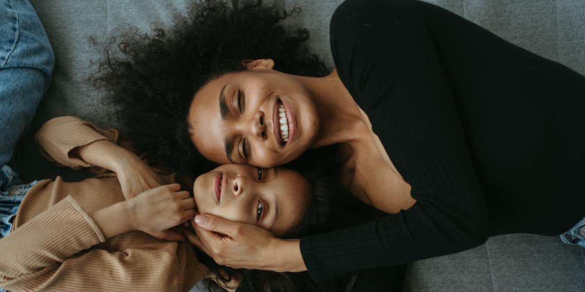 mom and daughter cuddling while lying down