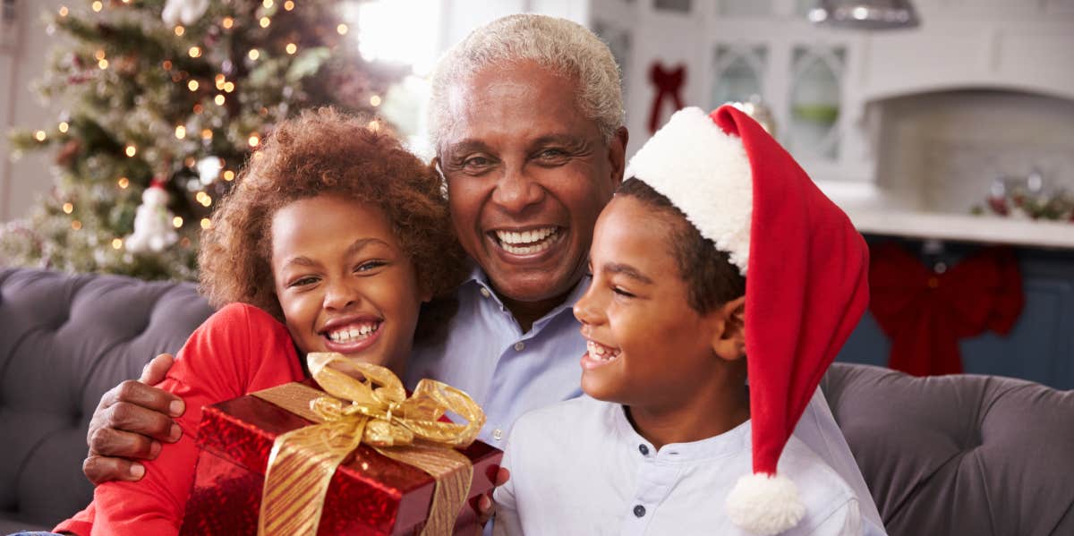 Grandfather with grandchildren opening gifts