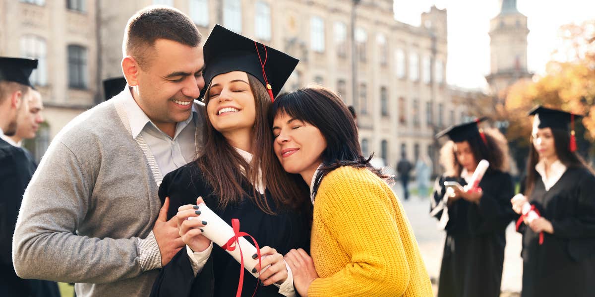 Parents embracing daughter at graduation
