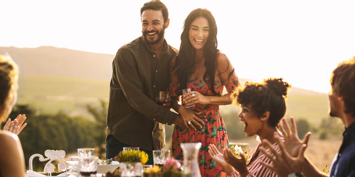 Young couple announcing their pregnancy at party