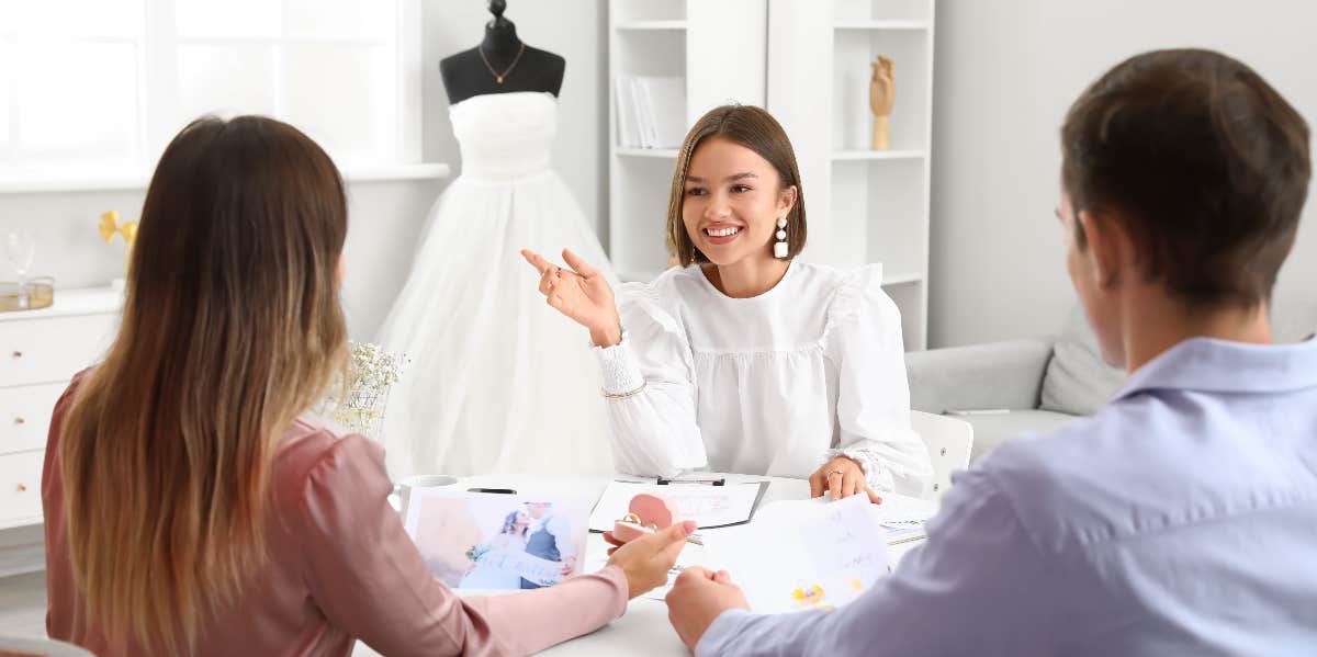 Wedding planner discussing ceremony with clients in office