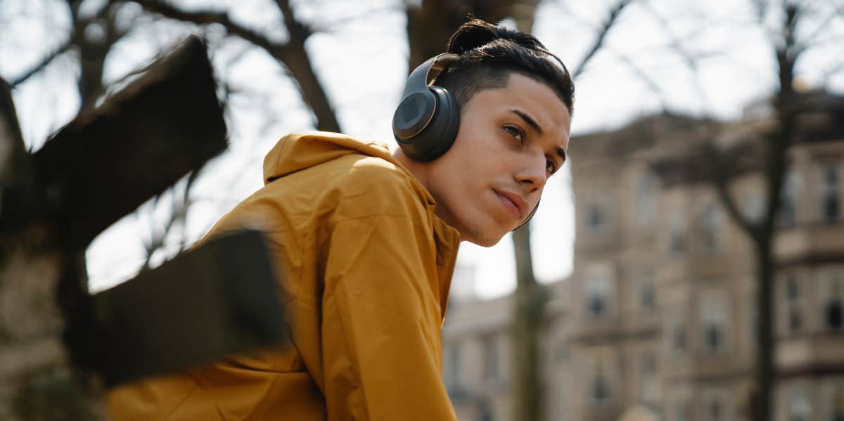 Teen boy with headphones using mobile phone