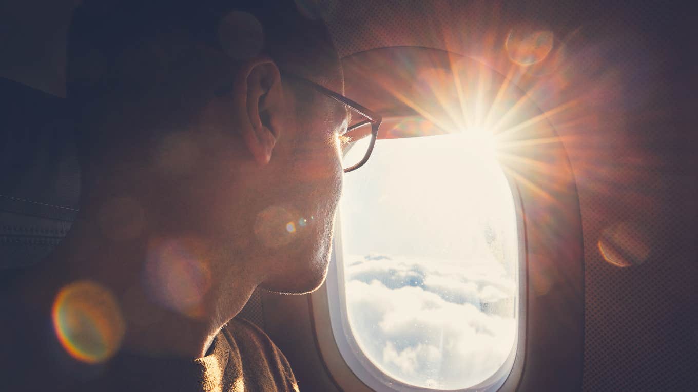 man looking out airplane window 