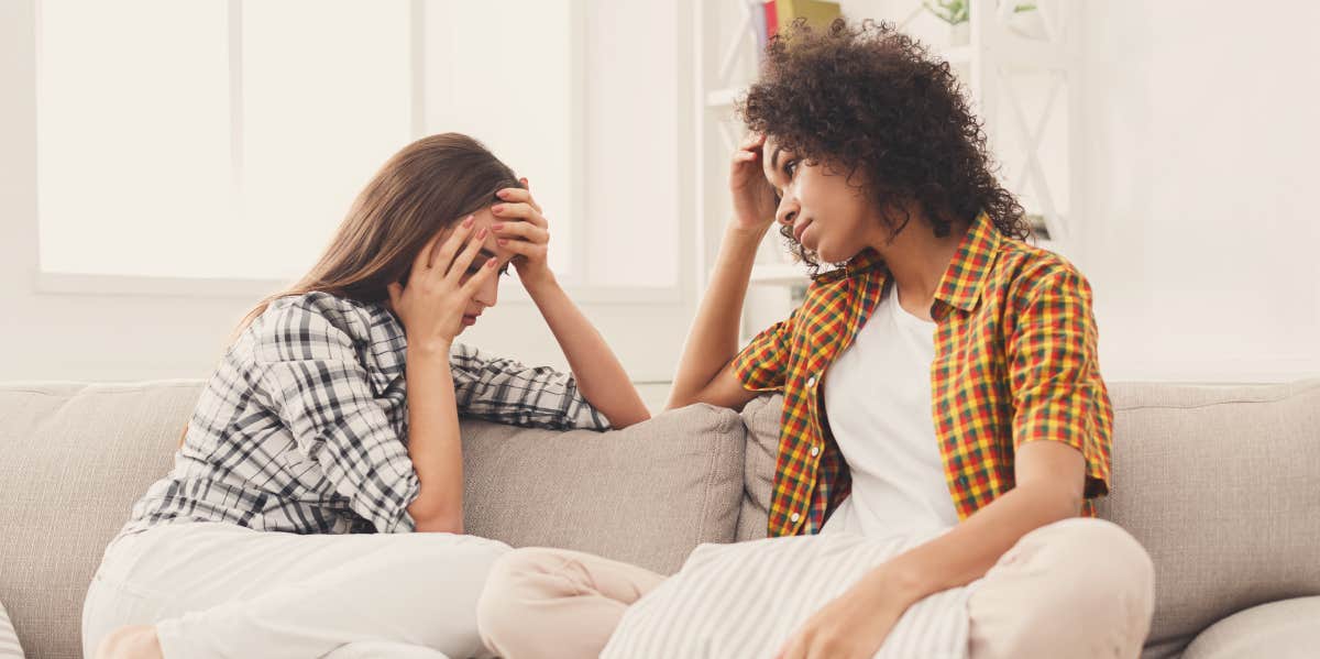 Two women conversing on couch