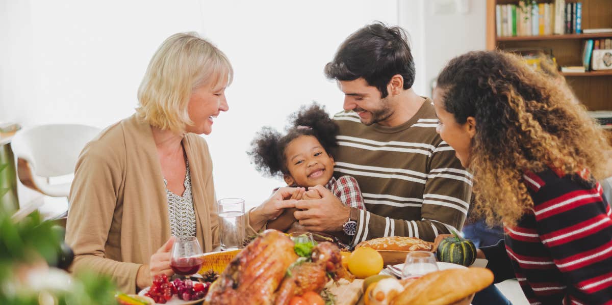 family having thanksgiving dinner around table
