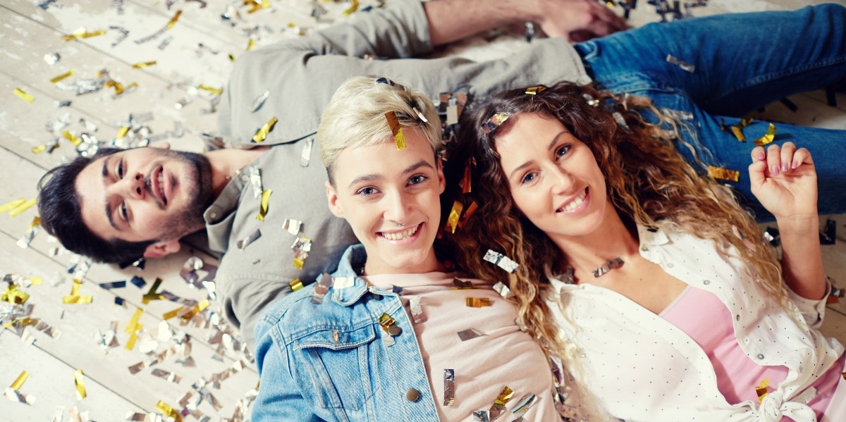 two women and one man with confetti