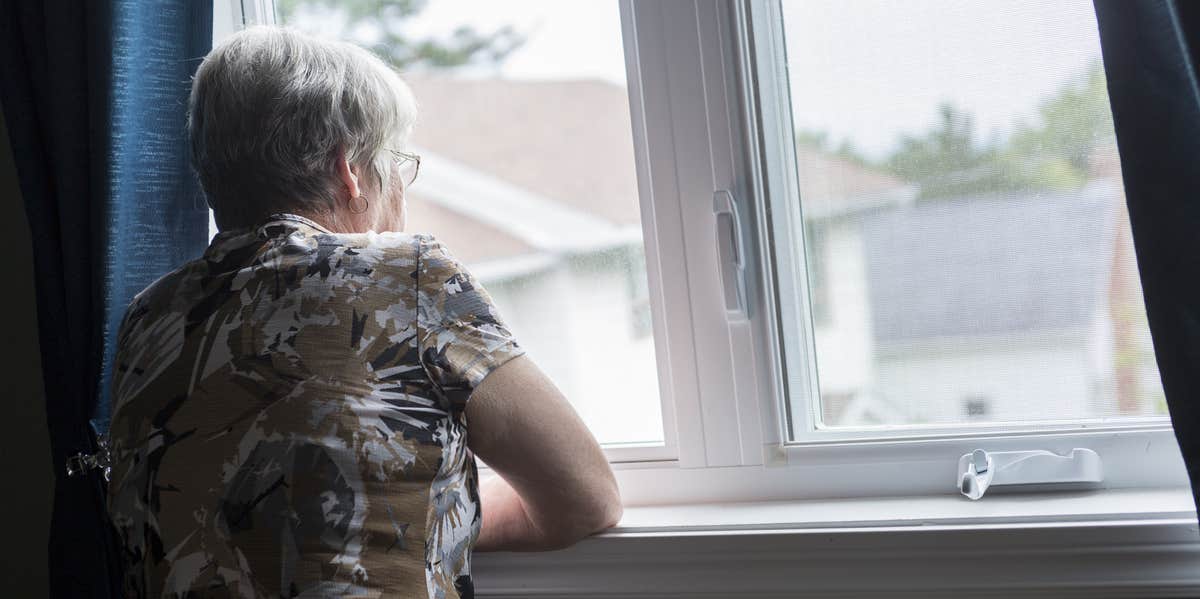 old woman looking out window