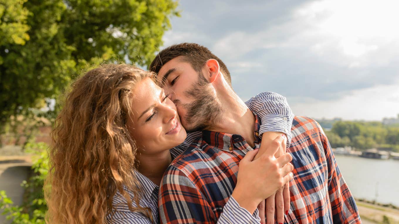 man kissing woman on cheek