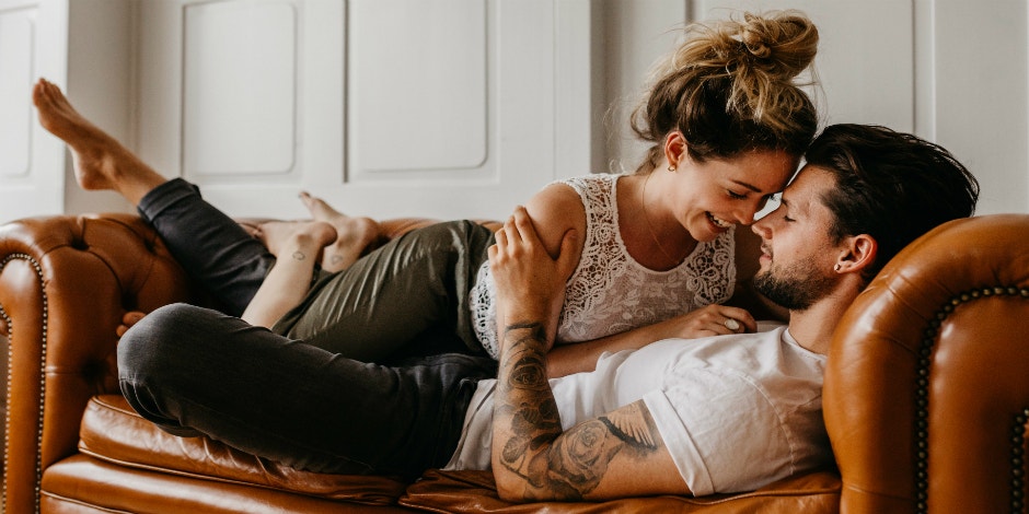 wife and husband cuddling on couch