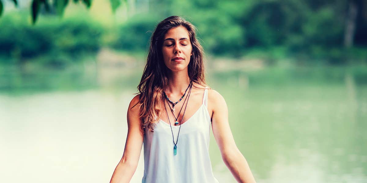 Woman praying by a lake