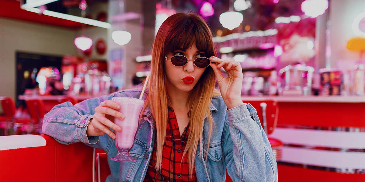 woman in diner drinking milkshake