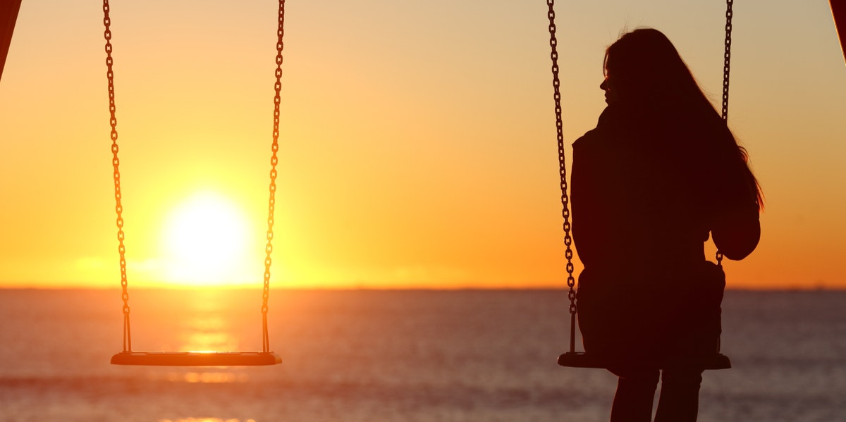 woman sitting swing sunset