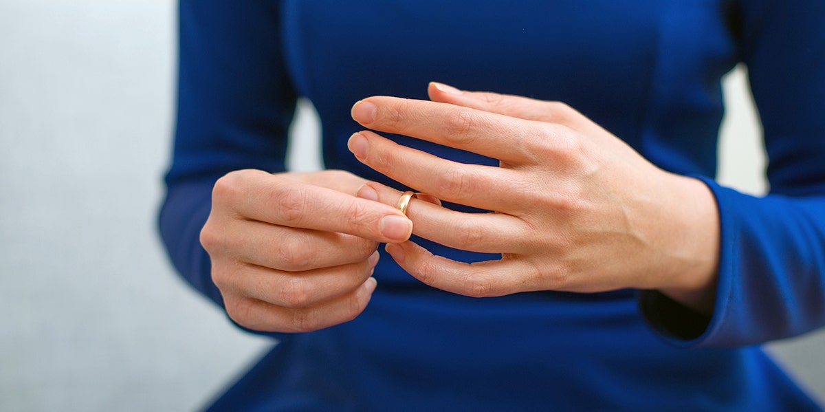 The Weird Reason One In Three Women Are Removing Their Wedding Rings woman fidgeting with wedding ring